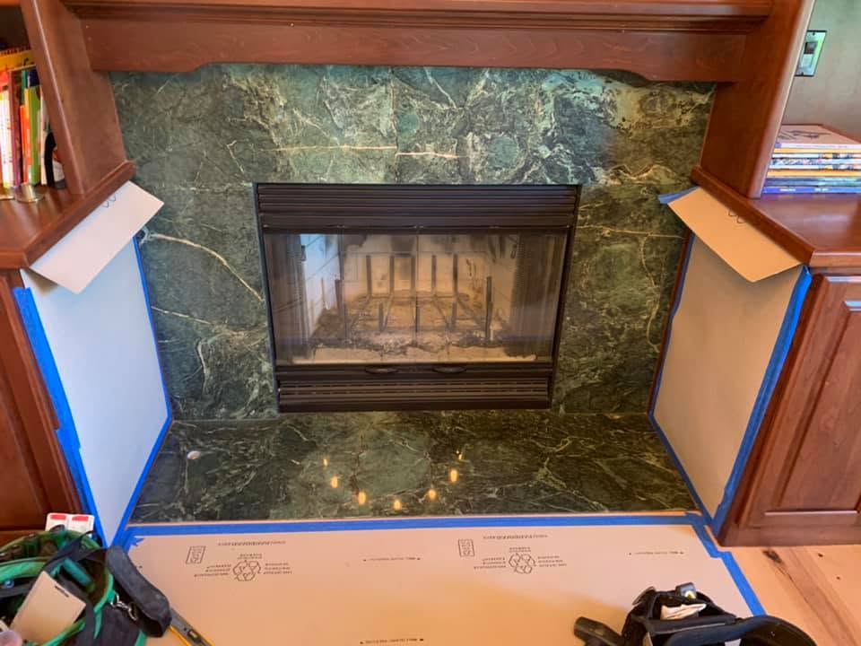 Before: dark green fireplace surround and hearth between wood built-ins