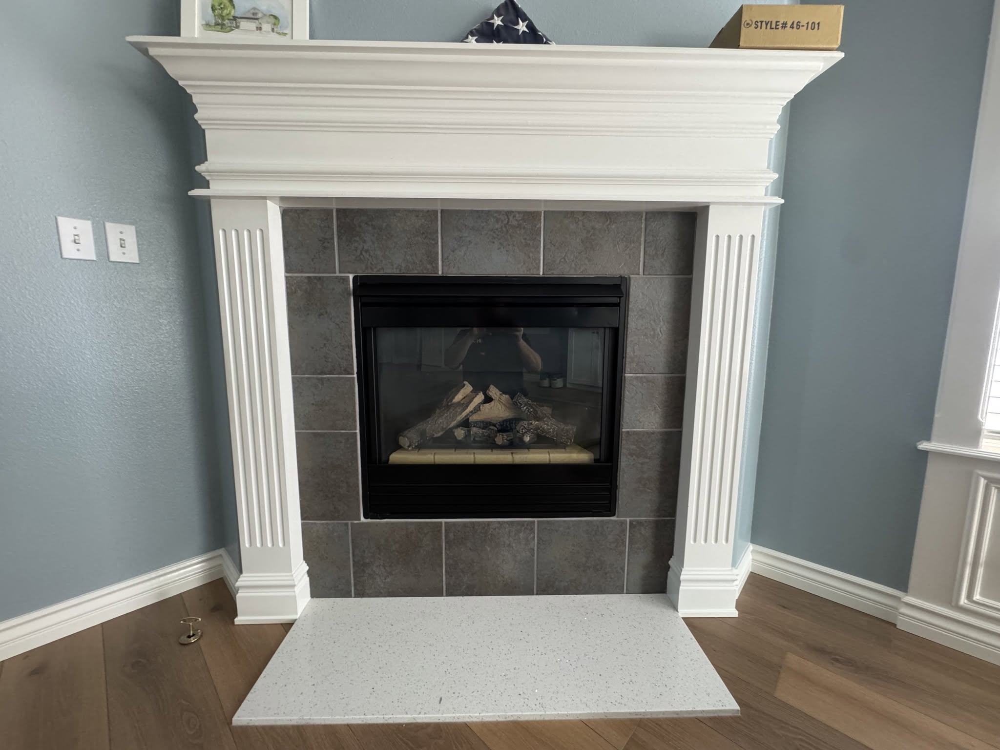 Before: fireplace with large dark square tile